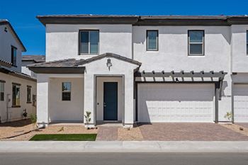 a white house with a garage door in front of it